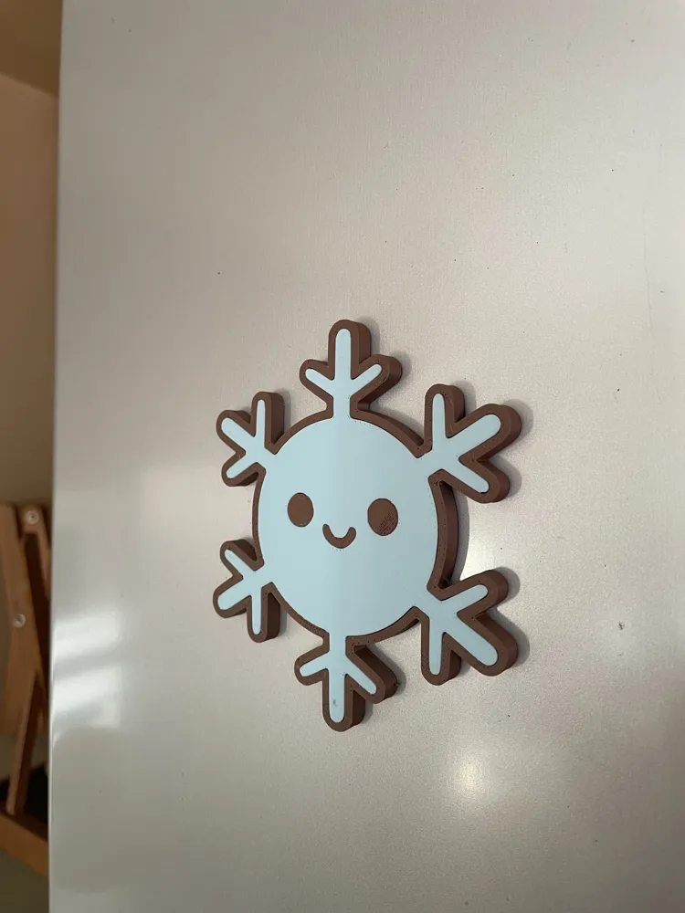 Snowflake fridge magnet on a refrigerator door